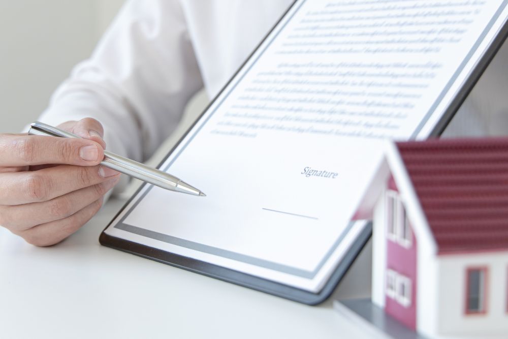 Homeowners vs Renters Insurance comparison showing policy paperwork and home model during insurance coverage review