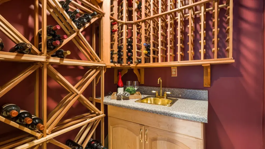 Home wine cellar with wooden wine racks and a small bar sink