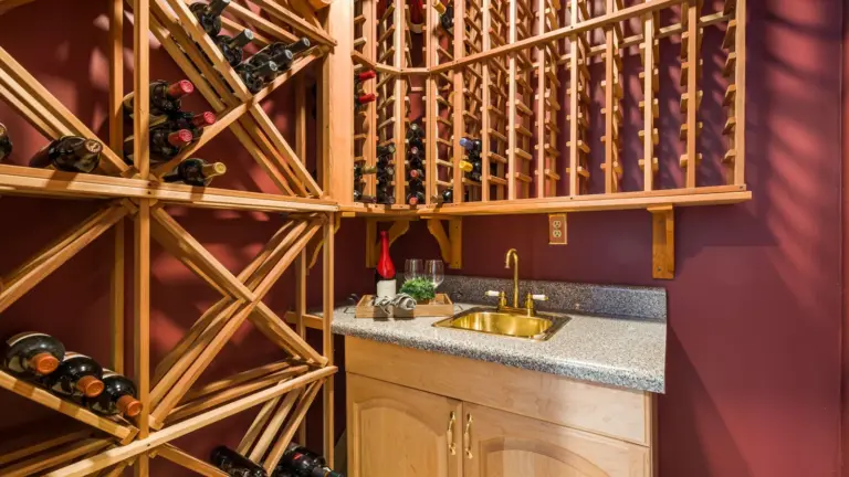 Home wine cellar with wooden wine racks and a small bar sink