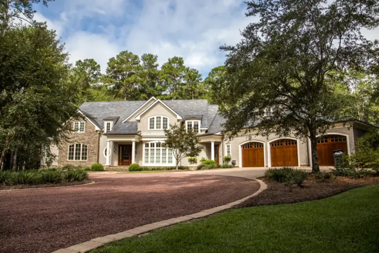 Large stone and shingle home with a three-car garage and circular driveway
