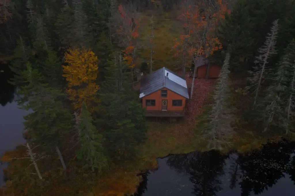 Cabin beside the water surrounded by autumn foliage in New Hampshire