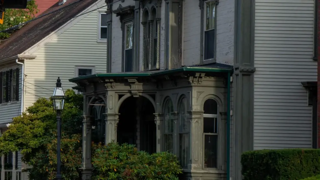 Victorian house with an arched entry porch beside a clapboard home on a historic street in Portsmouth, New Hampshire