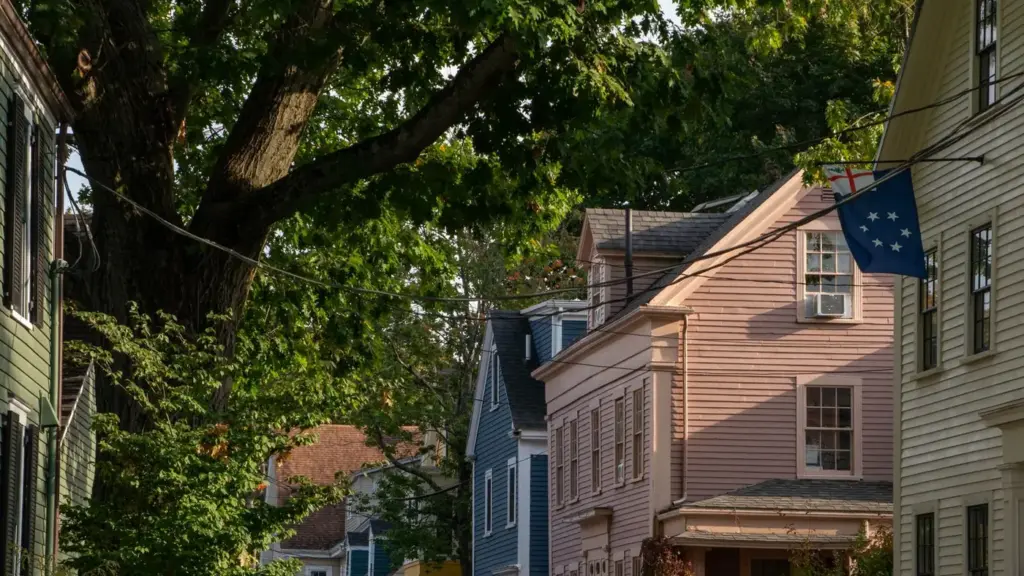 Tree-lined street of older clapboard houses in Portsmouth, New Hampshire, in late-afternoon light